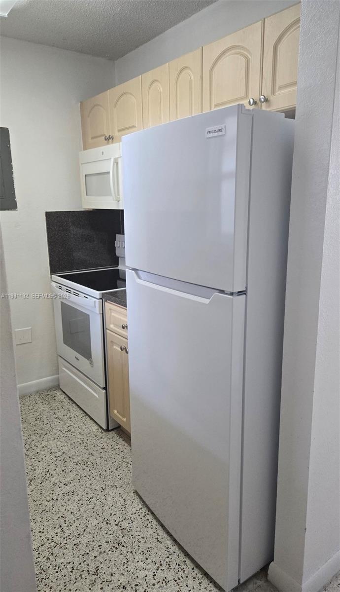 142 Southwest 18th Avenue, Unit 30 Miami, FL 33135 - Photo 8 of 11 a white refrigerator freezer and a stove sitting inside of a kitchen