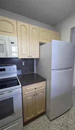 a kitchen with a stove top oven and cabinets