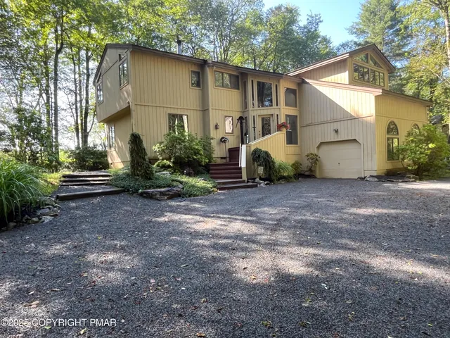 a view of a house with backyard and trees