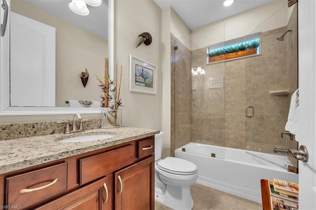 16424 Windsor Way Alva, FL 33920 - Photo 25 of 48 a bathroom with a granite countertop sink a toilet a mirror a bathtub and shower