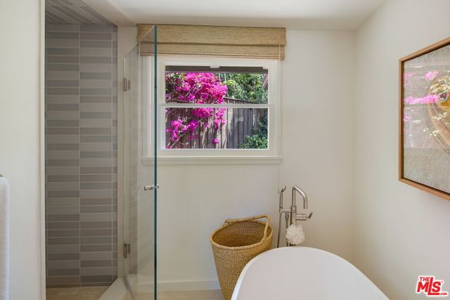 a bathroom with a toilet and a painting on the wall