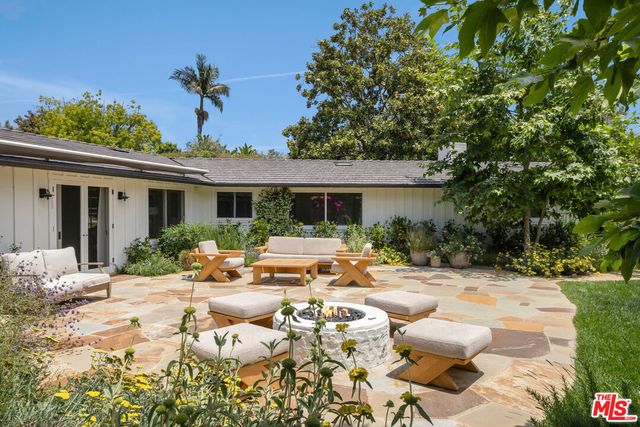 a view of a house with yard and sitting area