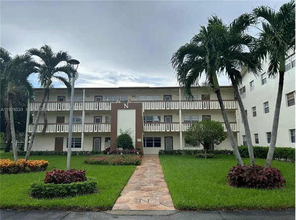 a front view of a multi story building with yard