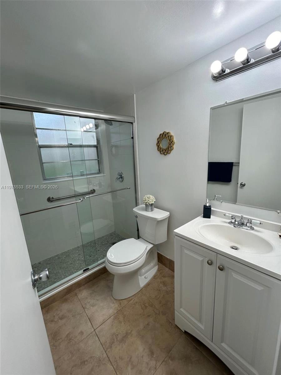 550 Mansfield M, Unit 550 Boca Raton, FL 33434 - Photo 24 of 30 a bathroom with a toilet sink and shower