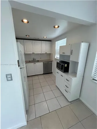 a kitchen with a sink a microwave and cabinets