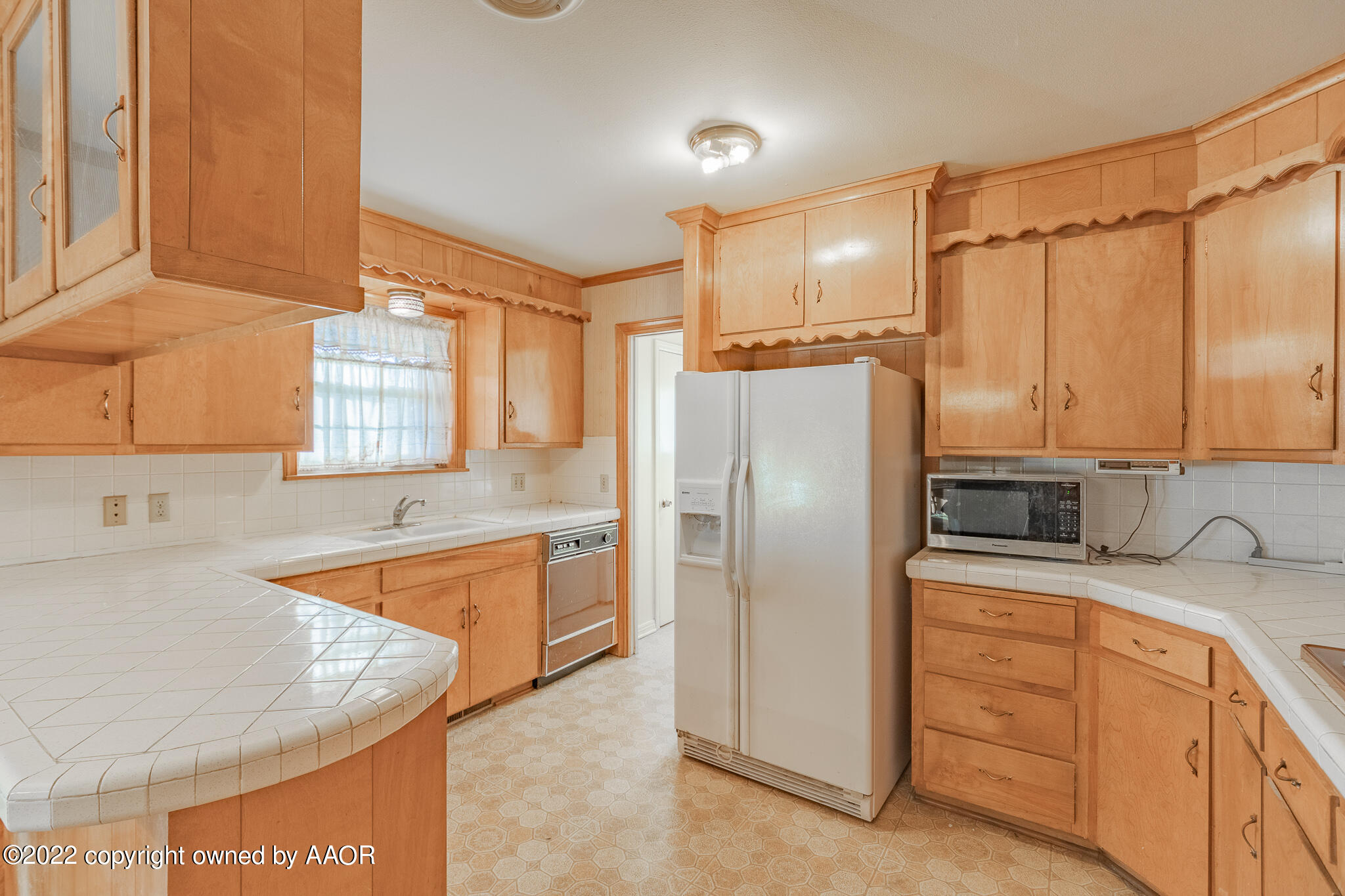 6013 Calumet Road Amarillo, TX 79106 - Photo 10 of 26 a kitchen with stainless steel appliances granite countertop a refrigerator a sink and white cabinets