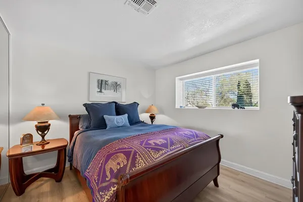 a bedroom with a bed and wooden floor