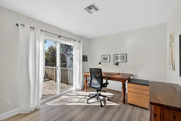 a view of a workspace with furniture and a window