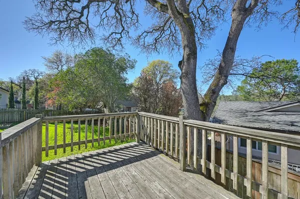 a view of a balcony with wooden floor and fence