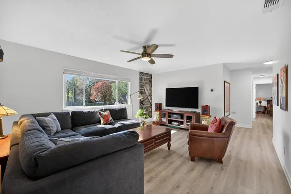 a living room with furniture wooden floor and a flat screen tv