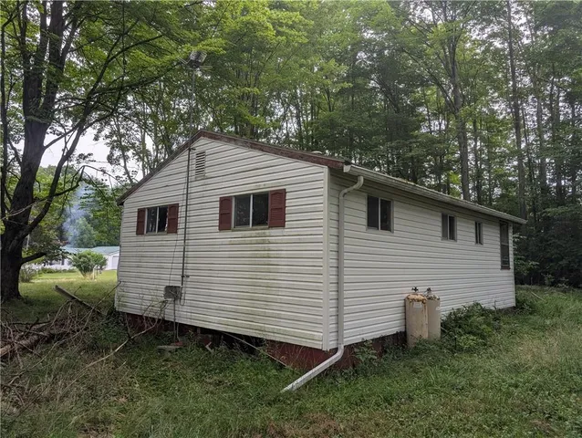 a view of a small white house and a yard