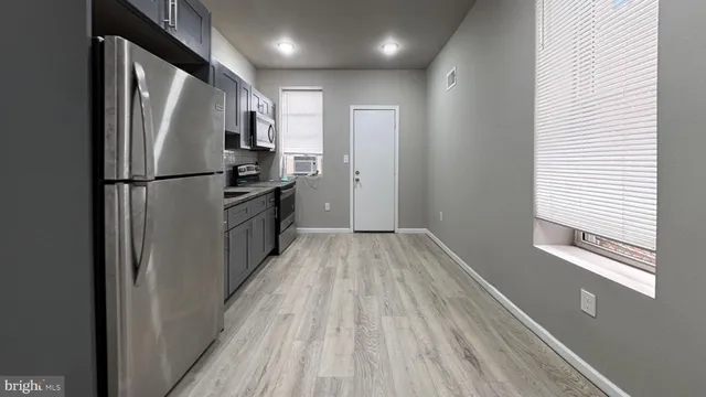 a view of a refrigerator in kitchen and wooden floor