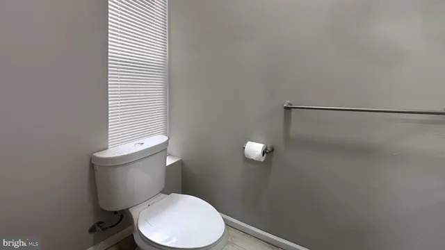 a white toilet sitting next to a bathroom sink and a window
