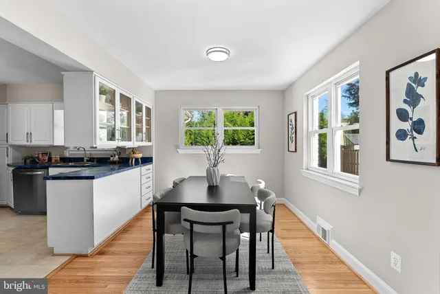 a kitchen with a table chairs and windows