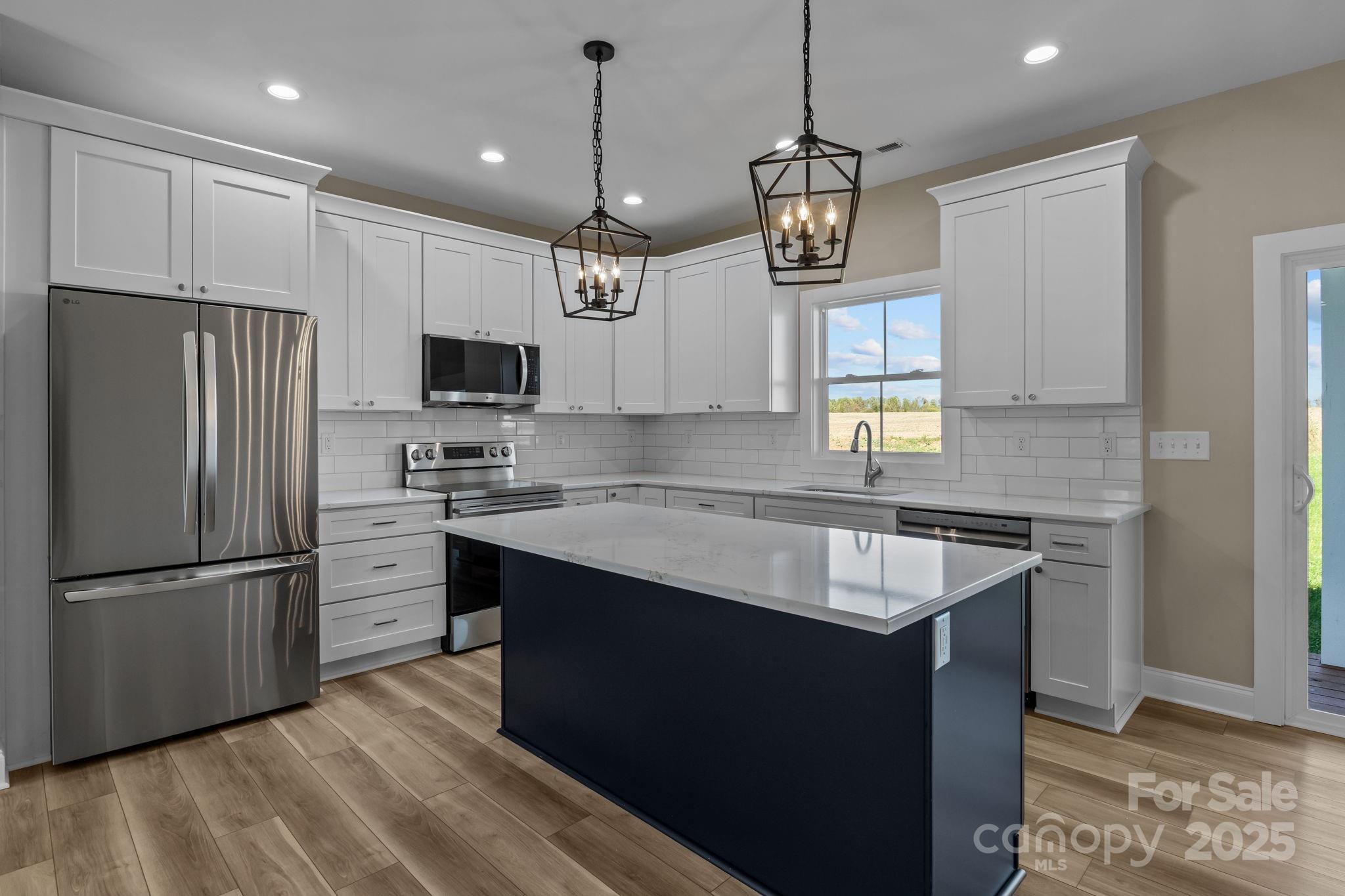 1716 Jennings Road Olin, NC 28660 - Photo 15 of 48 a kitchen with kitchen island granite countertop stainless steel appliances a sink a refrigerator a center island and cabinets