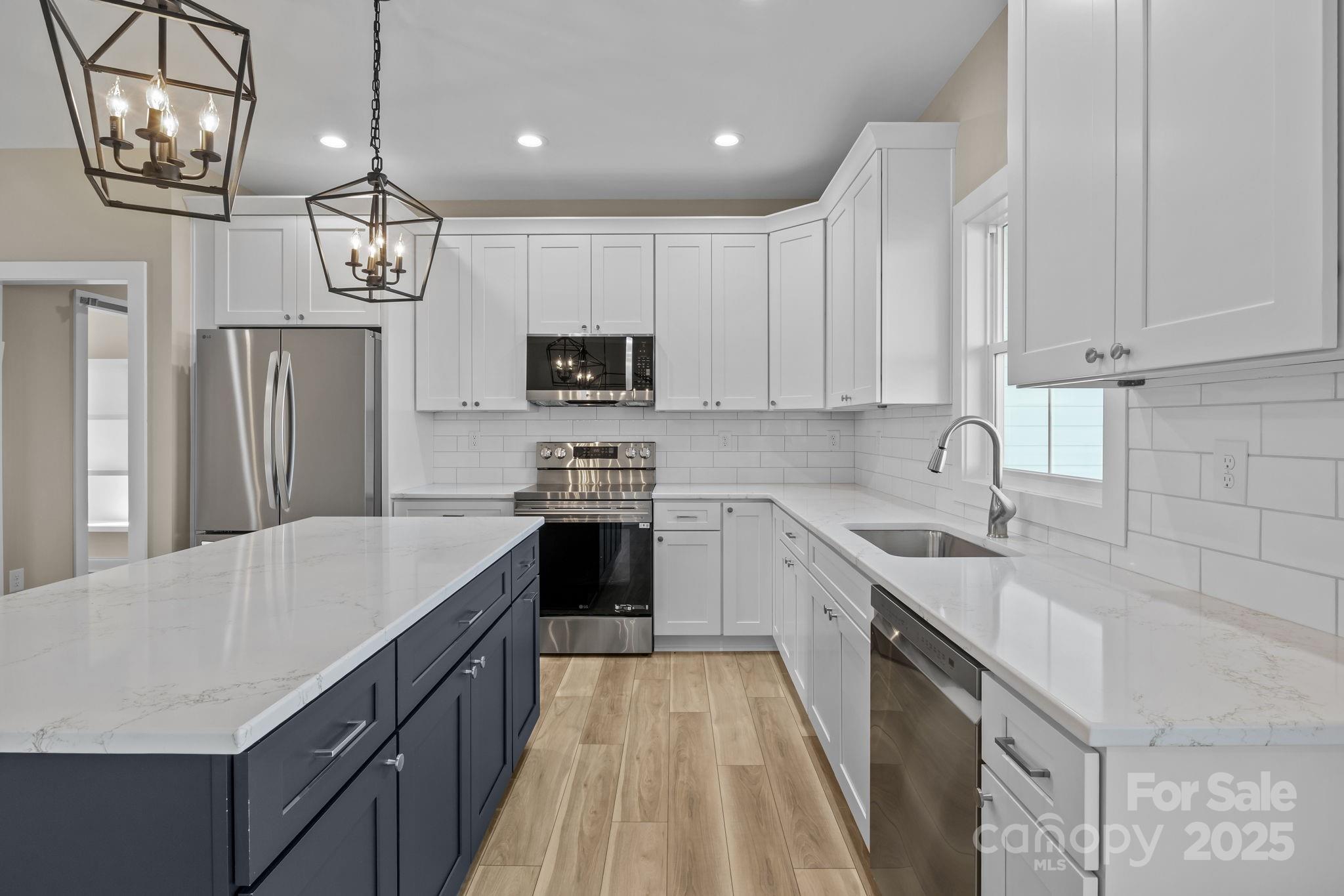 1716 Jennings Road Olin, NC 28660 - Photo 16 of 48 a kitchen with kitchen island granite countertop stainless steel appliances a sink a stove a refrigerator cabinets and a counter top space