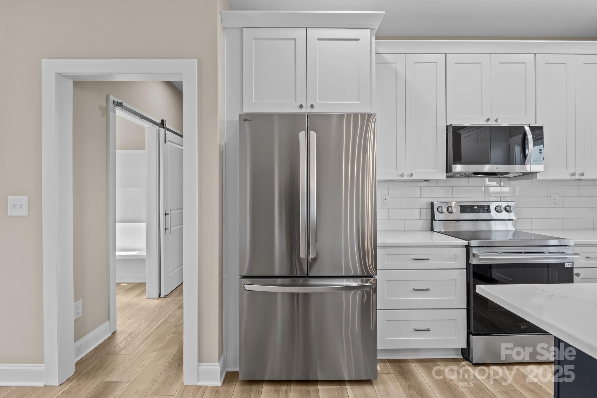 1716 Jennings Road Olin, NC 28660 - Photo 21 of 48 a kitchen with white cabinets and stainless steel appliances