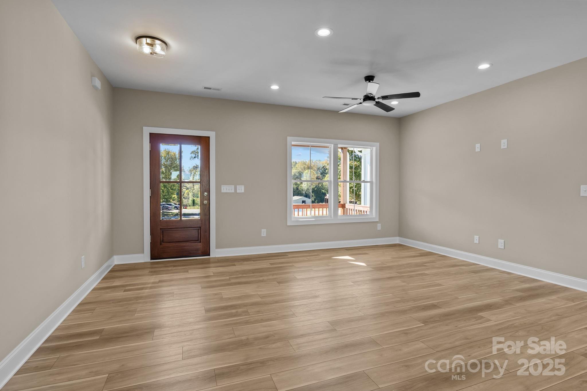1716 Jennings Road Olin, NC 28660 - Photo 10 of 48 an empty room with wooden floor a ceiling fan & windows