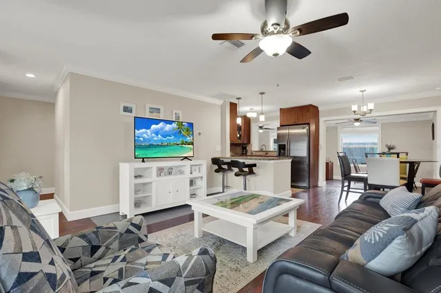 a living room with furniture a flat screen tv and kitchen view