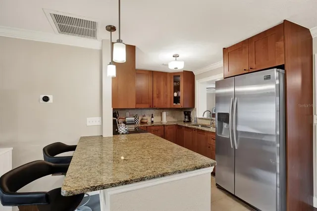 a kitchen with stainless steel appliances granite countertop a sink refrigerator and microwave