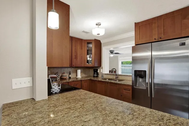 a kitchen with granite countertop a refrigerator and a sink