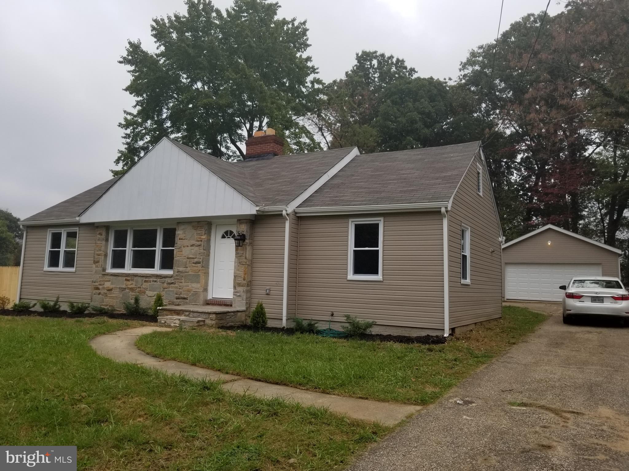 6828 Campfield Road Baltimore, MD 21207 - Photo 1 of 26 a front view of a house with a garden and yard