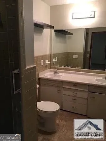 a bathroom with a toilet a sink and mirror