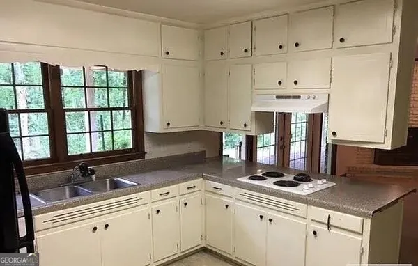 a kitchen with stainless steel appliances cabinets a large window and a sink