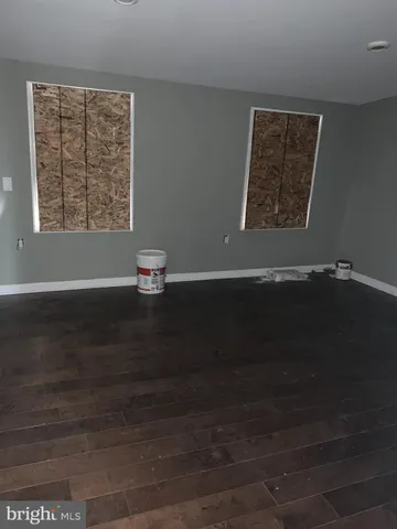 an empty room with wooden floor and a window