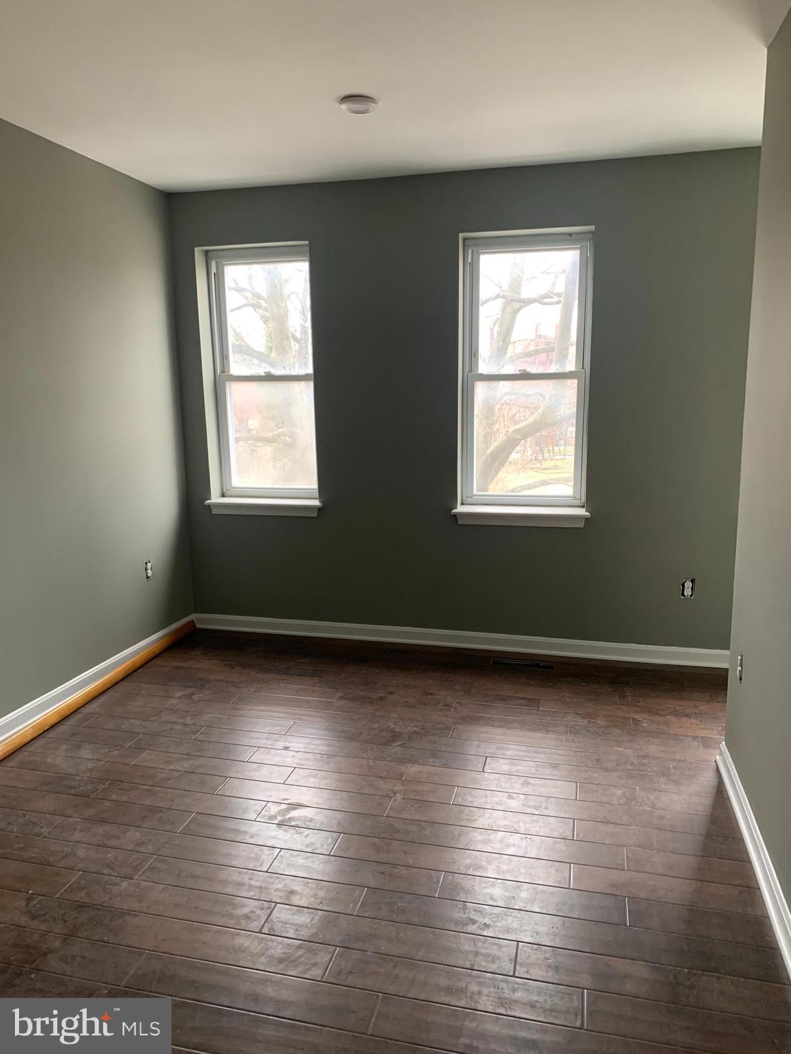 943 North Mount Street Baltimore, MD 21217 - Photo 6 of 11 an empty room with wooden floor and windows