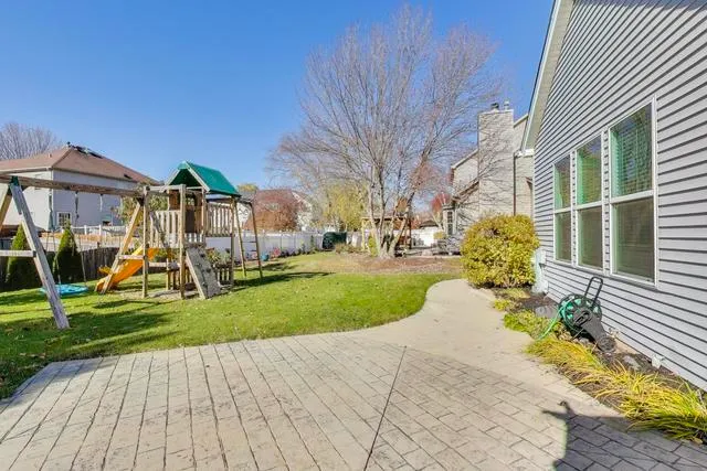 a view of a backyard with table and chairs and wooden fence