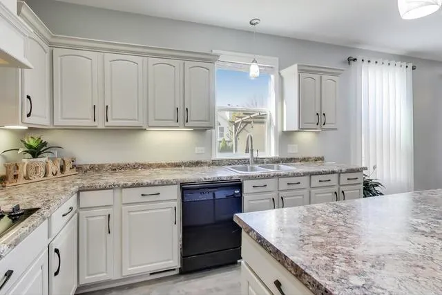 a kitchen with sink stove and refrigerator