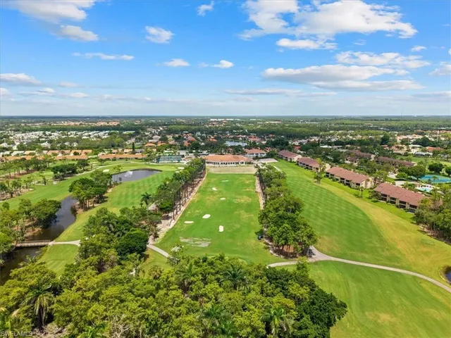 a view of a swimming pool with lawn chairs under an umbrella