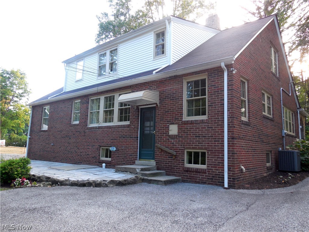 Back of house view with stone patio.