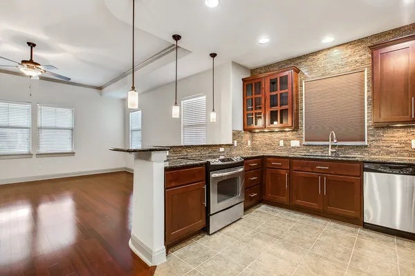 a kitchen with stainless steel appliances granite countertop wooden floors and sink