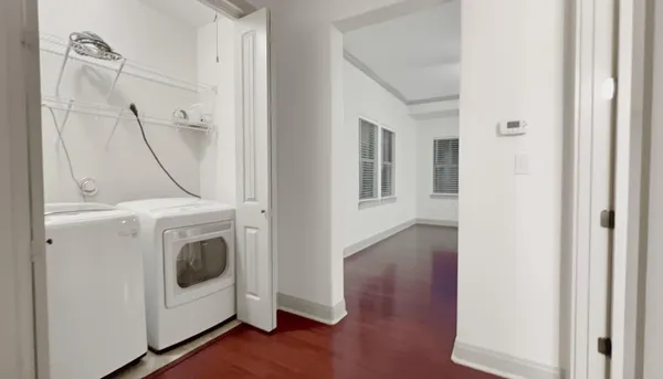 a view of a storage and utility room with wooden floor
