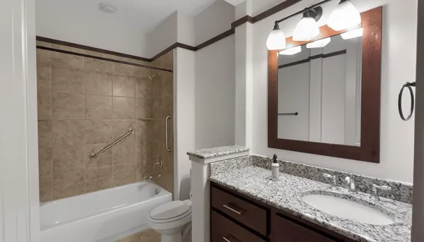 a bathroom with a granite countertop sink toilet and shower