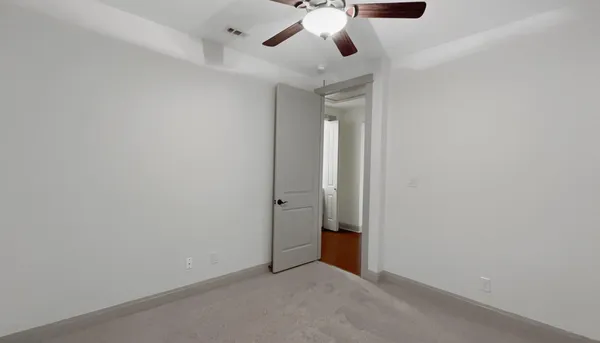 an empty room with a chandelier fan and a ceiling fan