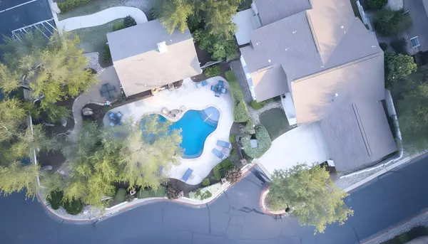 an aerial view of a house with a yard and black garage