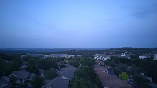 an aerial view of house with yard and mountain view in back