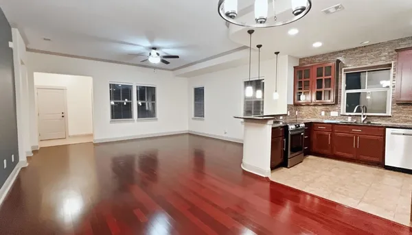 a kitchen with stainless steel appliances granite countertop wooden floors and view living room