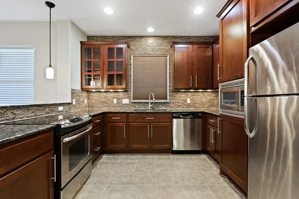 a kitchen with stainless steel appliances granite countertop a sink and a refrigerator