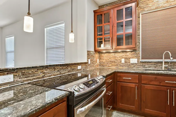 a kitchen with granite countertop a sink stove and cabinets