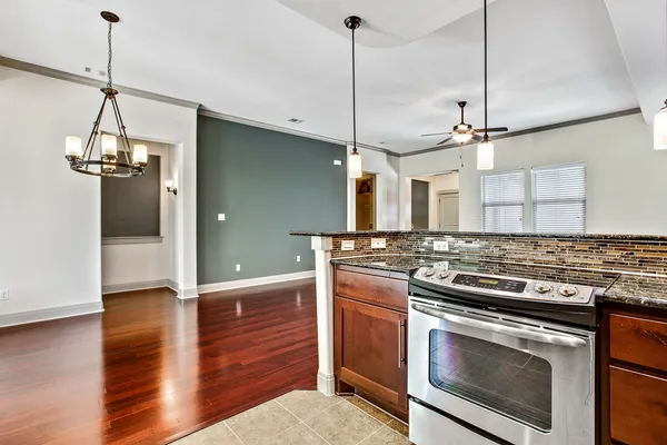 a kitchen with stainless steel appliances granite countertop a stove and a wooden floor