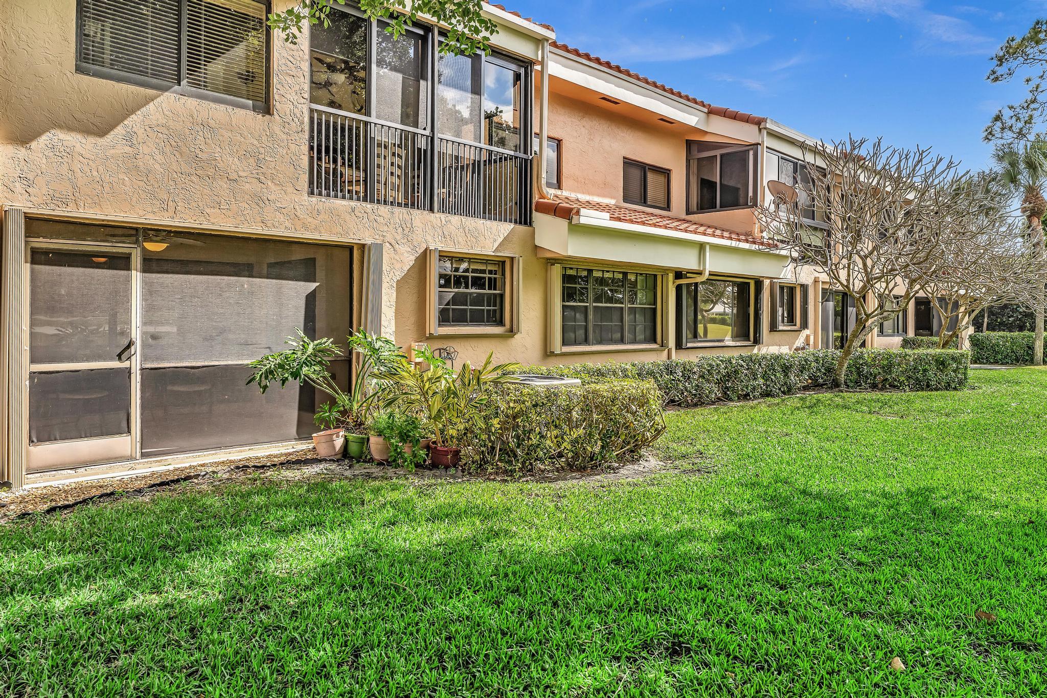 17372 Boca Club Boulevard, Unit 405 Boca Raton, FL 33487 - Photo 55 of 74 a front view of a house with a yard