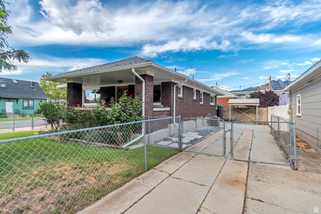 4883 South Center Street Murray, UT 84107 - Photo 30 of 32 Brick exterior with a covered front porch, established landscaping and RV parking