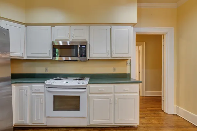 a kitchen with granite countertop white cabinets and stainless steel appliances