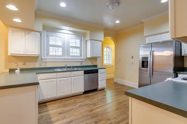 a kitchen with stainless steel appliances granite countertop a sink a stove a refrigerator and island