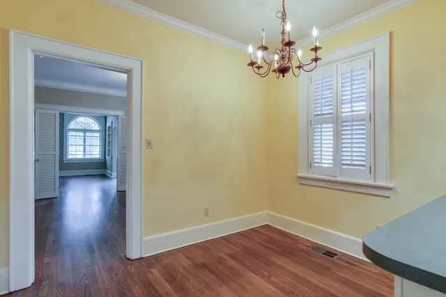 a view of a livingroom with wooden floor and a chandelier