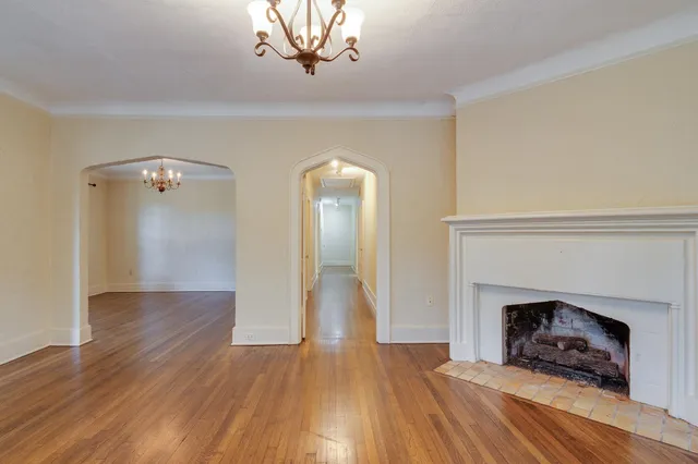 a view of a livingroom with wooden floor and a fireplace
